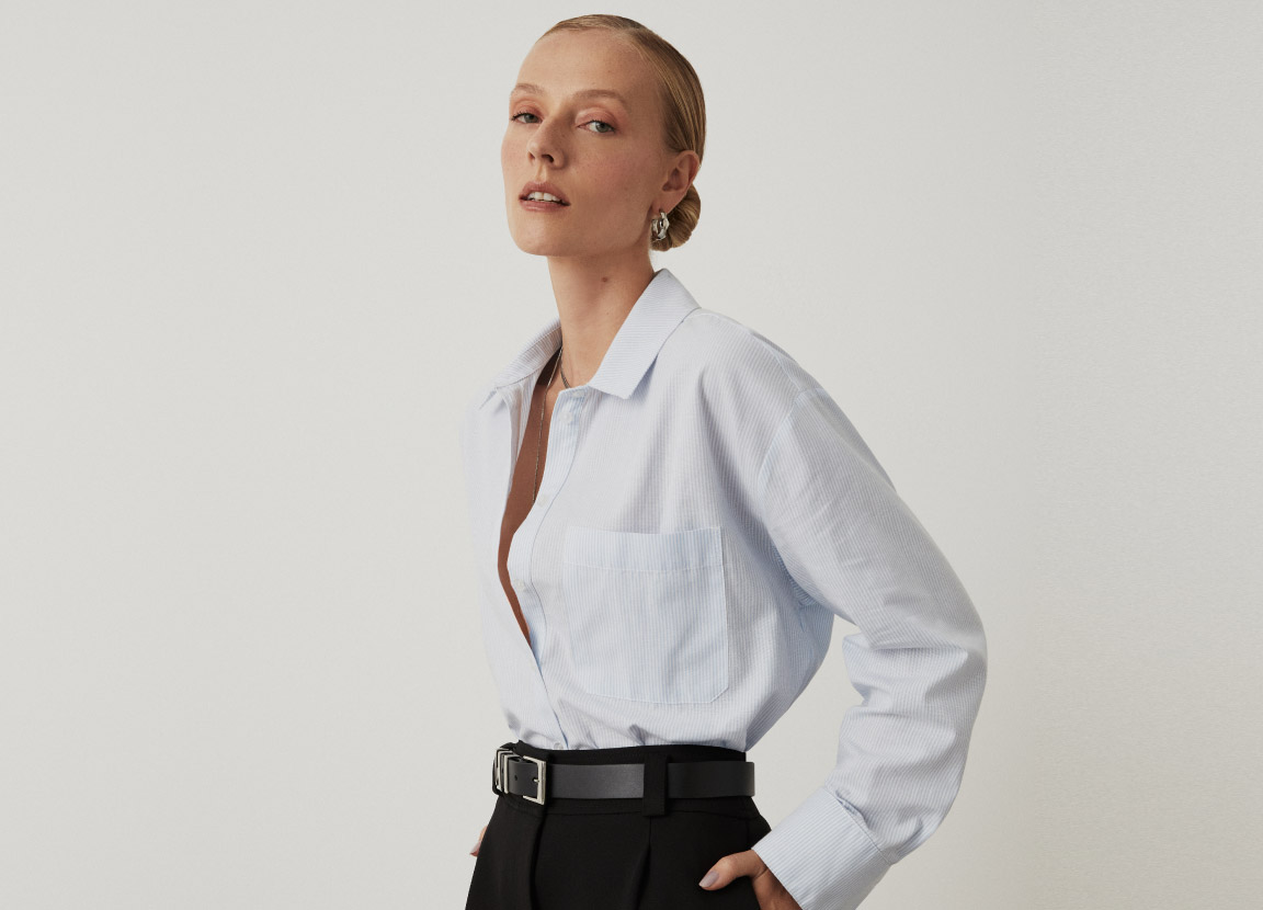 modelo com camisa social branca e calça de alfaiataria preta representando look atemporal feminino para trabalho